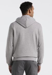 Grijze hoodie met een zachte textuur, geribde manchetten en tailleband. De achterkant heeft een centrale naad en een ontspannen pasvorm.