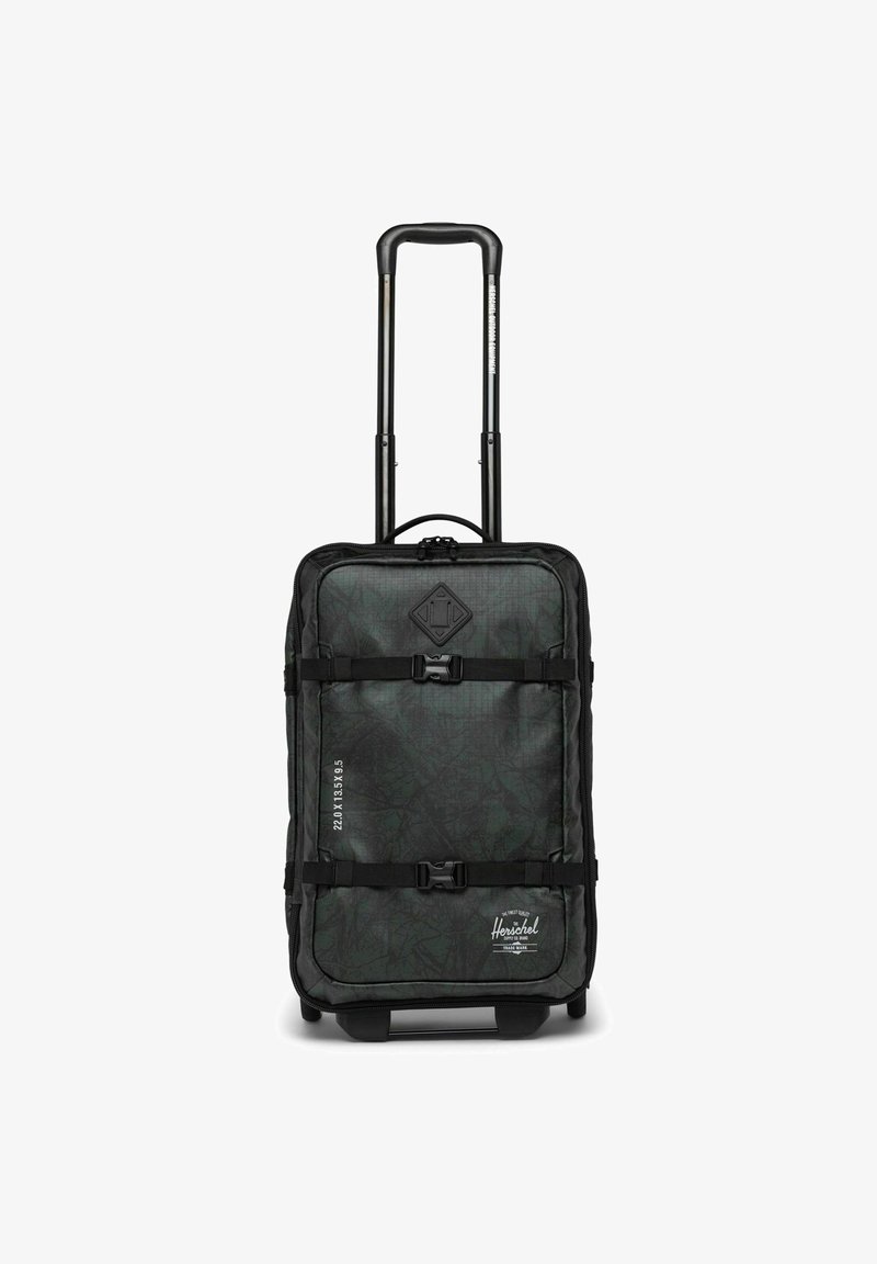 Valise à roulettes noire et verte avec une surface texturée, une poignée réglable, deux sangles de sécurité et des détails de taille imprimés sur le côté.