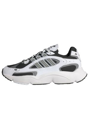 Biało-czarny sportowy sneaker z szarymi paskami, zapinany na sznurowadła, z grubą, amortyzowaną podeszwą, pokazany z profilu bocznego, skierowany w lewo.