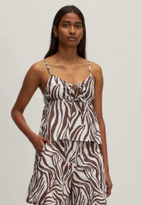 Bruin en wit zebra-streep top met spaghettibandjes en een strikdetail aan de voorkant, gecombineerd met bijpassende shorts. Katoenen stof.