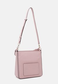 Mjuk rosa läder crossbody-väska med justerbar rem, framficka och guldfärgad metalldetaljer på en vit bakgrund.
