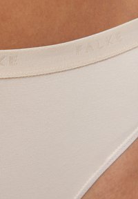 Slip in misto cotone beige chiaro con una morbida trama e una cintura con il logo "FALKE" in rilievo. Bordi senza cuciture per un comfort ottimale.