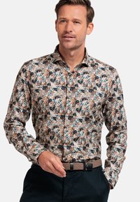 Chemise à manches longues à motifs avec des tons terrestres, des motifs floraux et de feuillages, col avec boutons et coupe régulière. Portez-la avec une ceinture texturée.