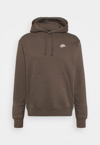 Brun huvtröja i mjukt material med en framficka i känguru-stil och vit Nike-logotyp på bröstet. Ärmar och nederkant är ribbade.