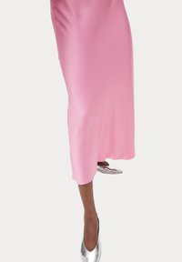 Abito midi in satin rosa con taglio dritto e una leggera lucentezza, abbinato a scarpe argentate a punta.