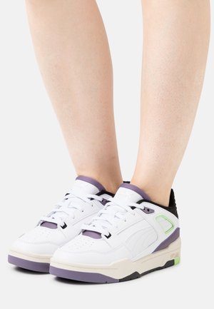 Baskets blanches avec des accents violets et verts, dotées d'un dessus en cuir texturé, d'un design bas et d'un col rembourré pour le confort.