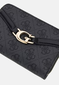 Cartera negra texturizada con logos en relieve repetidos, correa de cuero negra y detalles en metal dorado con la letra "G".