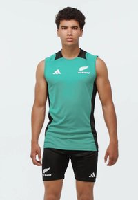 Turkusowy, sportowy top na ramiączkach z czarnymi akcentami, z logo "All Blacks" i paskami Adidas. W zestawie z czarnymi szortami, o gładkiej teksturze materiału.