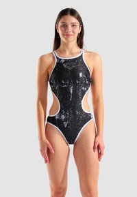 Costume intero bianco e nero con aperture laterali, caratterizzato da un motivo marmorizzato, design con schiena a corsetto e rifiniture bianche a contrasto.
