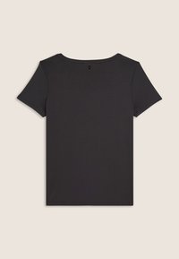 Camiseta negra de manga corta en un tejido suave y liso. Presenta un cuello redondo y un pequeño logo en la parte posterior del cuello. Diseño y color uniforme.