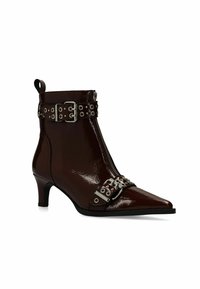 Pointed-toe enkelboot in glanzend bordeauxrood lakleer. Voorzien van een zijrits, decoratieve gespbanden en zilveren hardware-accenten.