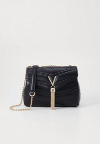 Črna prešita usnjena torbica z zlatim jermenom iz verige. Ima izrazit V-obliki zaponko in dekorativni verižni dodatek.