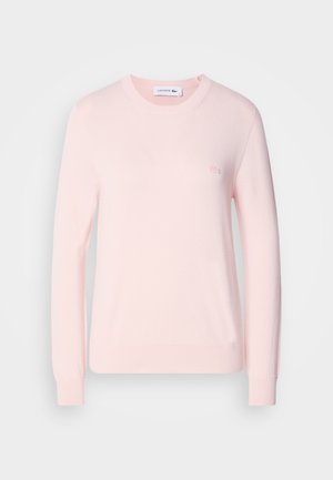 Heled roosa kootud pitsak, ümmarguse kaelusega, pikad varrukad ja soonikkoes mansetid. Rinna peal on väike tikandiga logo. Pehme tekstuur.