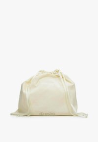 Worek ze sznurkiem, kremowa tkanina, miękka tekstura, zaokrąglony kształt, z białymi wstążkami i wytłoczonym logo na dole.