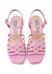 Infradito rosa con cinturini incrociati, punta quadrata e un leggero tacco a zeppa. Realizzati in pelle con una soletta testurizzata e bordi colorati.