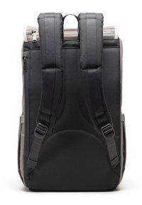 Zadný pohľad na šedý a čierny batoh s polstrovanými ramennými popruhmi, zipsovými vreckami a hornou rukoväťou.