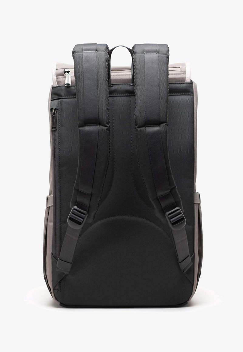 Zadní pohled na šedý a černý batoh s polstrovanými ramenními popruhy, zipovými přihrádkami a horním úchopem.