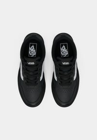 Black Vans sneakers with textured leather upper, flat black laces, silver side accents, and a logo on the tongue. Top view.