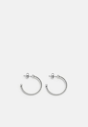 Boucles d'oreilles en argent en forme de hoop avec un design de corde texturé, dotées d'un fermoir en carré plat, créant ainsi un look minimaliste et moderne.