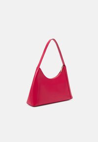 Sac à épaule en cuir fuchsia avec un haut arrondi, de forme triangulaire et une fermeture éclair dorée. Il dispose d'une seule bandoulière et d'une texture lisse.