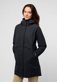 Giacca nera impermeabile con colletto alto, tasche frontali e vestibilità comoda. Realizzata in tessuto liscio e leggero, e presenta una chiusura con zip.