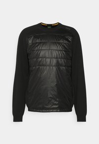 Czarny polarowy sweter z ocieplanym przednim panelem z nylonu. Posiada okrągły dekolt, długie rękawy oraz teksturowane wykończenie na ocieplanym elemencie.