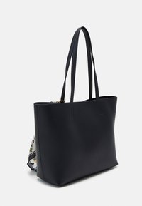 Bolso tote de cuero negro con dos asas largas, diseño elegante, textura suave y parte superior abierta. Presenta un acento estampado colorido en un lateral.