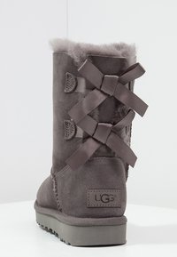Grå ruskindsstøvle med faux fur-foring. Har båndsnørebånd og et logopatch på hælen. Flad gummisål for godt greb.