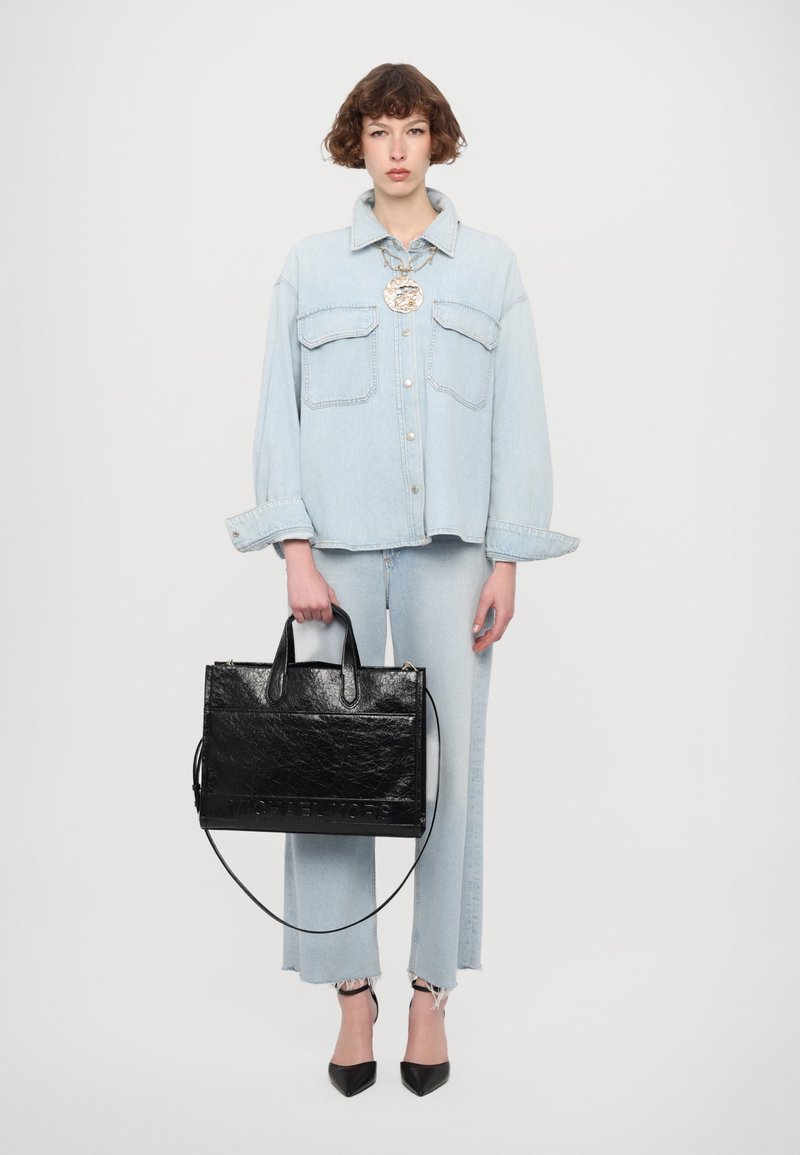 Gaiši zils denim oversize krekls ar divām krūšu kabatām, pāris ar atbilstošām denim biksēm. Melnā struktūrētā ādas soma ar divām rokturām.