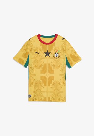 Kollane jalgpallimängija särk punase kraega, must täht, Ghana Jalgpalliliidu logo vikerkaarega, mustad Puma logod ja geomeetriline muster.
