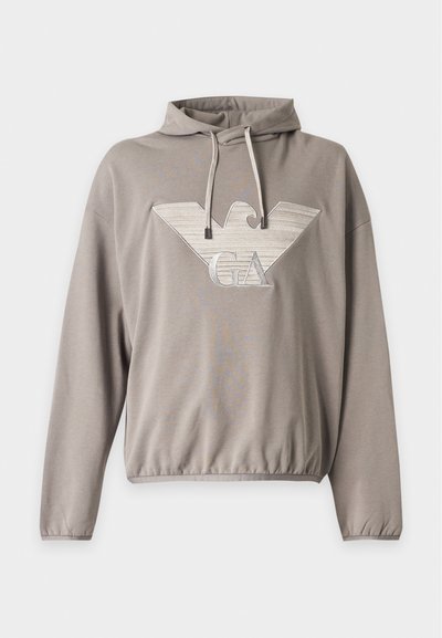 Sweat à capuche marron clair à manches longues avec un grand logo d'aigle stylisé avec les lettres "GA" sur le devant.