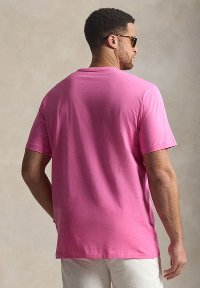 Κοντομάνικο t-shirt με στρογγυλή λαιμόκοψη σε φωτεινό ροζ βαμβάκι, με ομαλή υφή και απλό σχέδιο. Χωρίς ορατά μοτίβα ή διακοσμητικά στοιχεία.