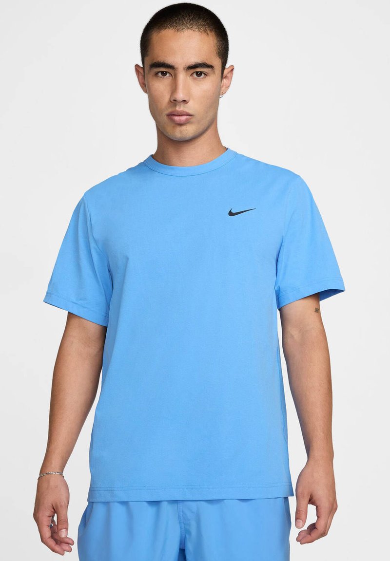 T-shirt Nike bleu clair à manches courtes et col ras du cou. Présente un petit logo noir sur la partie gauche de la poitrine. Texture de tissu lisse.