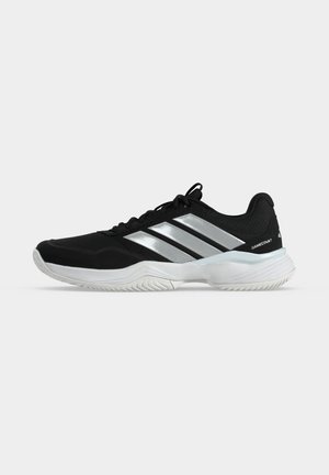 Chaussure de sport Adidas Gamecourt noire avec semelle blanche et trois bandes argentées sur le côté, conçue pour une utilisation sur court, vue de côté extérieur.