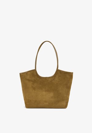 Olive green suede tote bag with two long handles, minimalist design, smooth texture, and subtle logo detail at the bottom front.