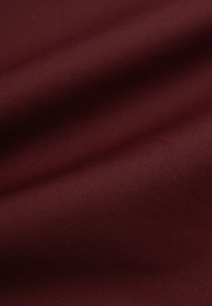 Bordowy materiał o gładkiej teksturze, z lekkim połyskiem i miękkim układzie, zaprezentowany w zbliżeniu, podkreślającym jego bogactwo.