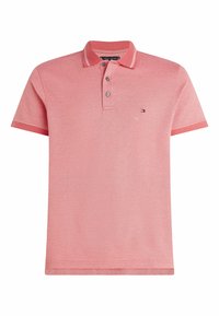 Różowa koszulka polo z krótkim rękawem, z trzema guzikami, paskowanym kołnierzykiem i małym prostokątnym logo po lewej stronie klatki piersiowej.
