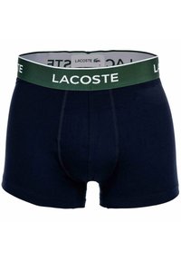 Boxer briefs Lacoste blu navy con un elastico verde scuro che presenta il logo bianco Lacoste e un piccolo emblema di coccodrillo.