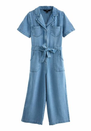 Combinaison en jean bleu clair avec manches courtes, boutonnage devant, col, poches poitrine, jambes larges, et ceinture en tissu attachée à la taille.