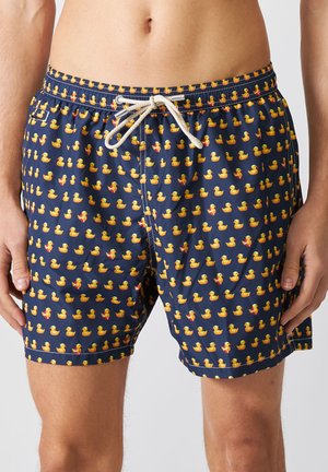 Pantaloni da bagno blu navy con un motivo ripetuto di anatre gialle e rosse, dotati di una vita con cordino e realizzati in tessuto leggero e liscio.