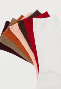 Set van zeven geribde sokken in verschillende kleuren: bordeauxrood, bruin, oranje, lichtroze, donkerbruin, rood en wit. Zachte textuur, enkellang.