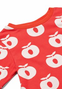 Camicia di cotone rossa con scollo rotondo, caratterizzata da un motivo ripetuto di mele bianche con foglie. Tessuto morbido e maniche corte.