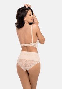 Spetsunderkläder i mjukt beige, med ett delikat blommönster, justerbara band och en högmidjad trosset med genomskinliga detaljer.