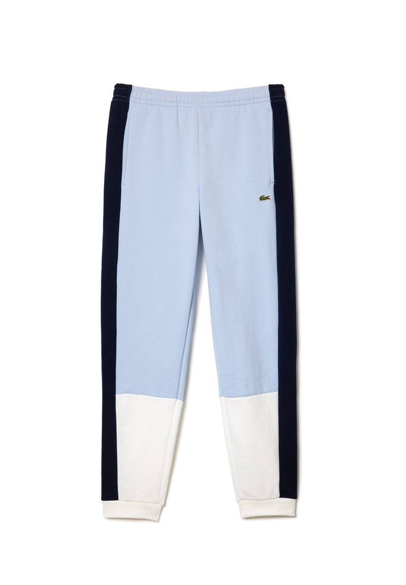 Pantalons de survêtement bleu clair avec des panneaux latéraux bleu marine et un ourlet blanc. Fabriqués en tissu doux, avec un logo brodé sur la cuisse gauche.