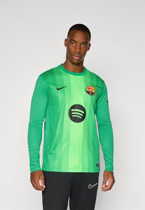 Žalia ilgomis rankovėmis futbolo marškinėliai su vertikaliomis juostelėmis, Nike logotipas, Spotify emblema ir FC Barcelona herbas ant krūtinės. Yra juodų akcentų.
