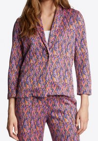 Blazer met een geometrisch patroon in roze, blauw en oranje. Driekwart mouwen, notch-kraag, enkele knoopsluiting en textiel met structuur.