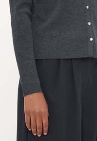 Dark gray knitted cardigan with a crew neckline, long sleeves, and silver buttons on the front. The fabric appears soft and textured.