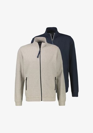 To herrejakker med lynlås, den ene i beige forrest og den anden i marineblå bagved, begge med ståkraver og lynlåslommer i siden.