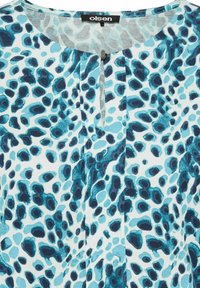 Leichte Bluse mit einem abstrakten Muster in Blau und Türkis im Leopardenstil, mit einem Schlüssel- Ausschnitt und einer glatten Textur.