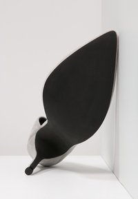 Scarpa elegante grigia in suede con tacco alto, punta affusolata e suola nera in gomma, caratterizzata da una superficie liscia e un design minimalista.